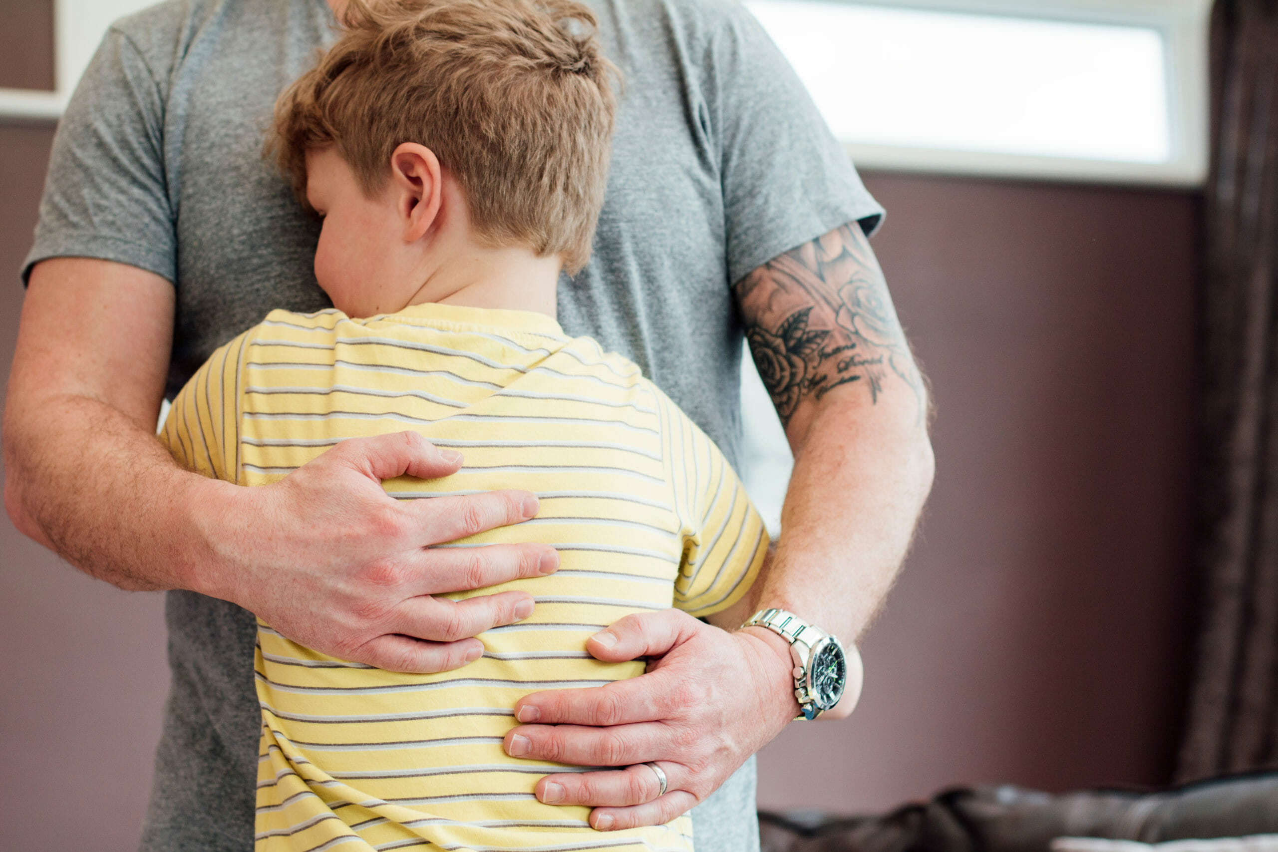 A boy hugs his father