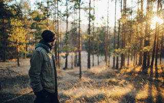 Young man walking in the beautiful forest outdoors