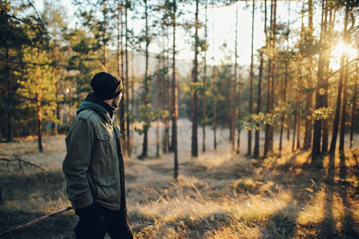 Young man walking in the beautiful forest outdoors