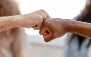 Diverse male hands giving fist bump