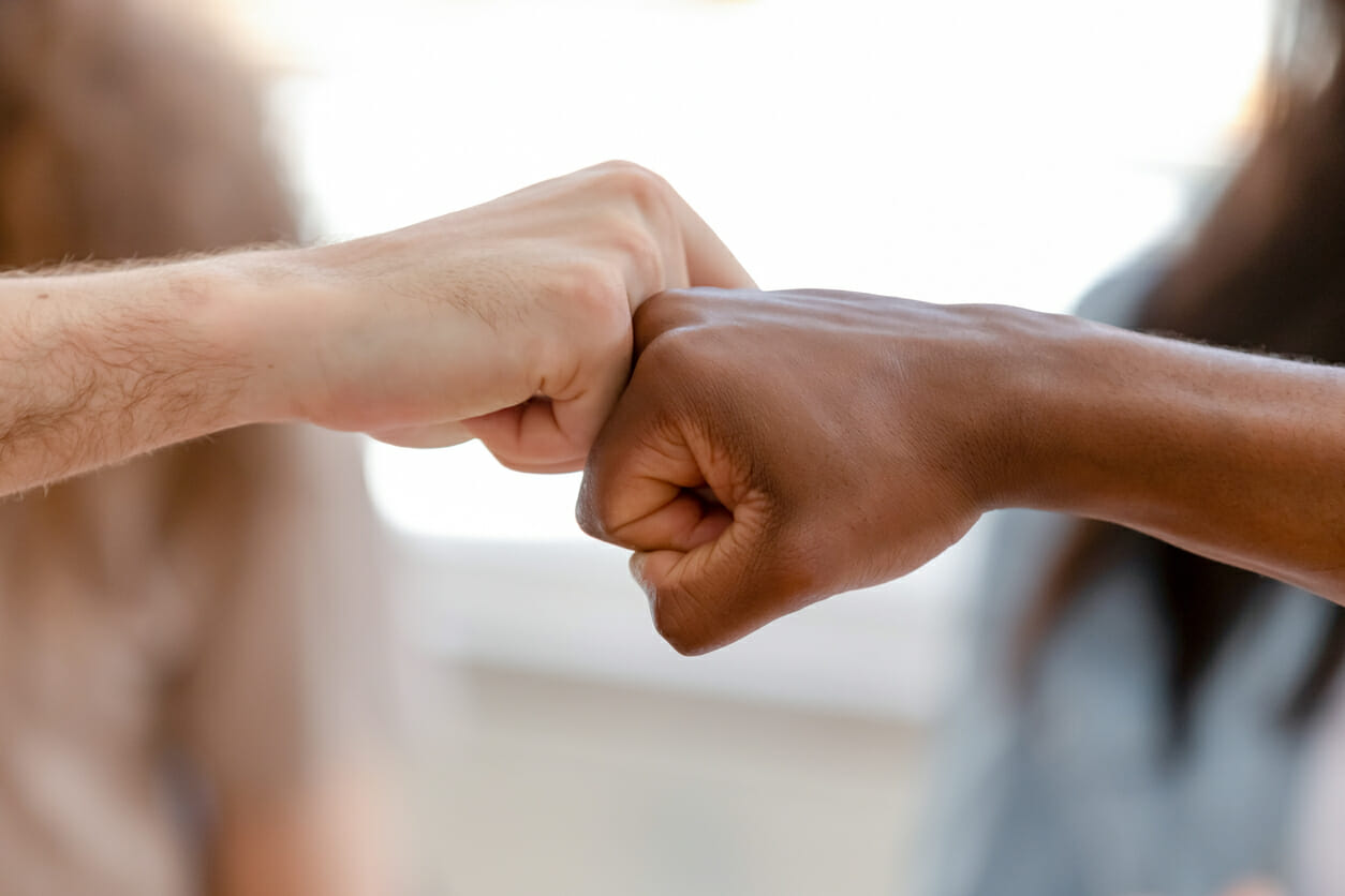 Diverse male hands giving fist bump