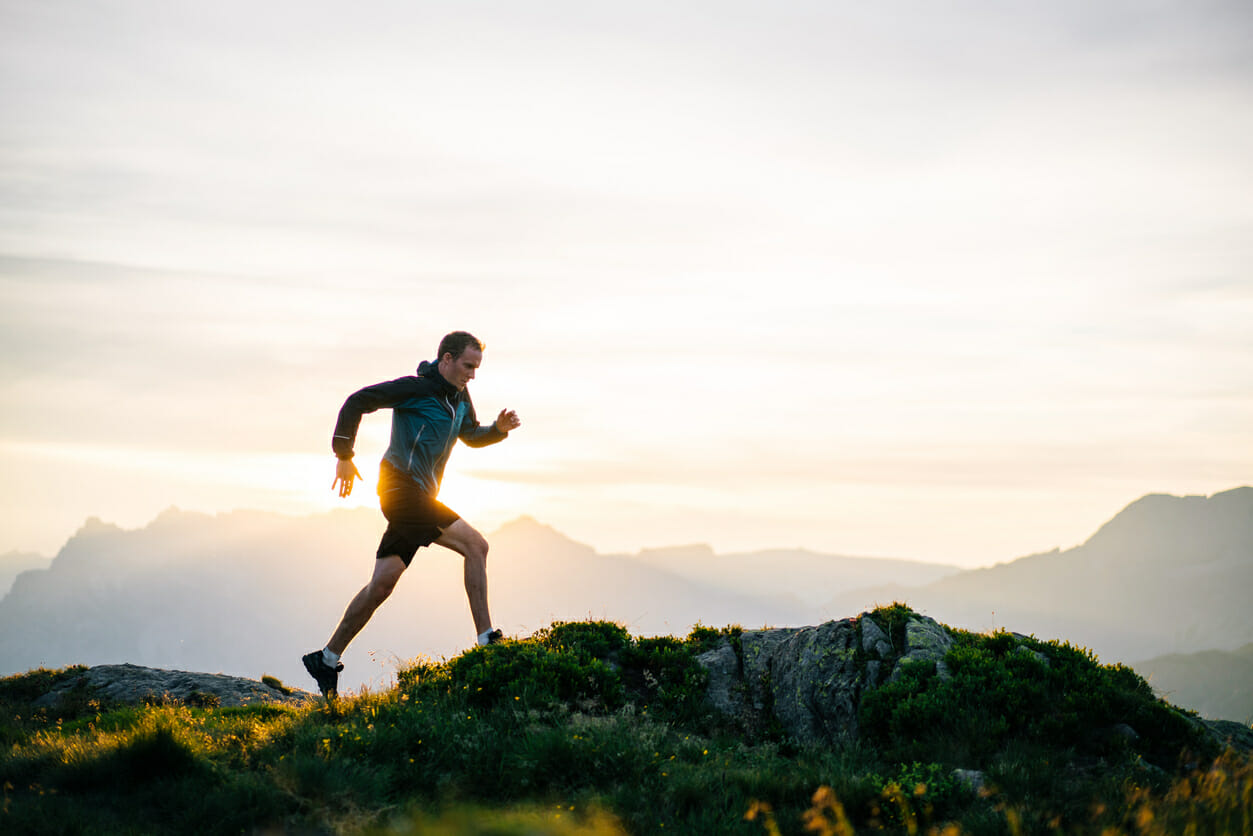 Young man runs on mountain ridge at sunrise Young man runs on mountain ridge at sunrise