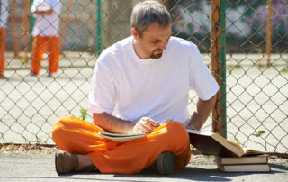 Man reading books at prison yard