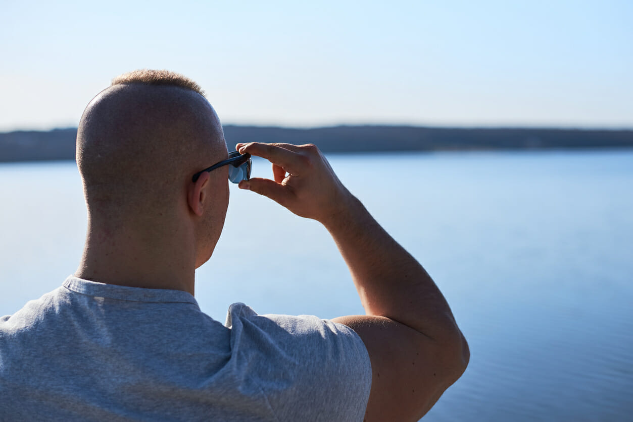 Muscle man is looking at the lake