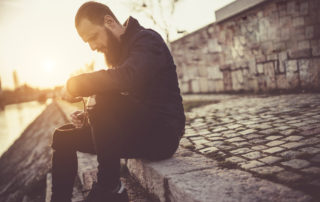 Sober man sitting by the river and enjoying life