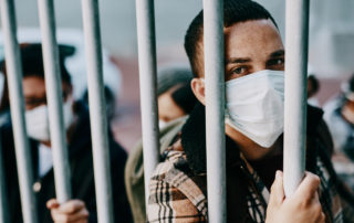 Shot of a young man wearing a mask in a jail