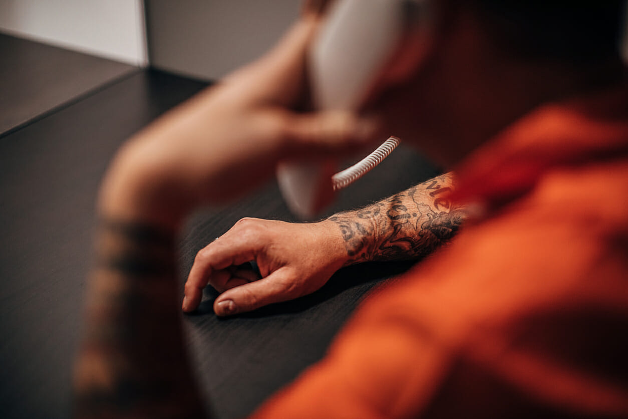 Male prisoner talking on phone in prison visit room