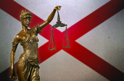 Lady Justice before a flag of Alabama