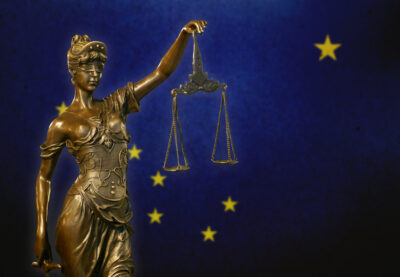 Lady Justice before a flag of Alaska