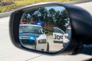 Two police car in a car mirror