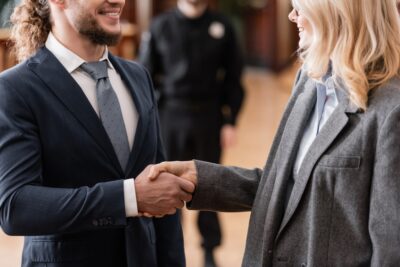 Smiling client shacking hand of a lawyer in the courthouse