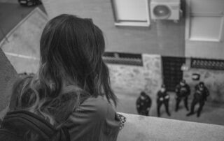 Young woman looking at policemen from the balcony